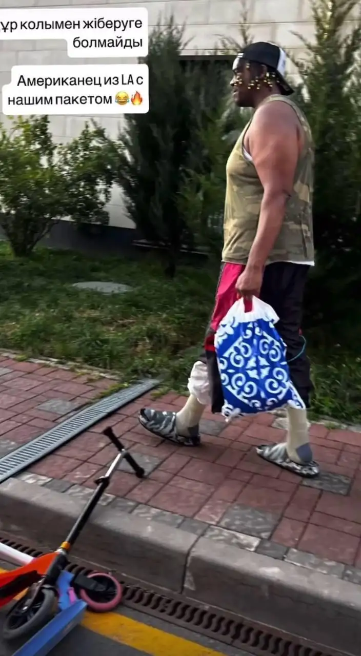 Просто бас-гитарист Дженнифер Лопес с пакетом из Казахстана идет по улице.